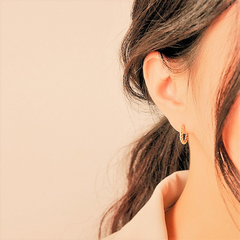 gold geometric mini stud earrings worn on model ear