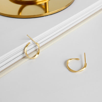 organic gold stud earrings close up irregular shape