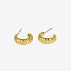 gold huggie hoop earrings worn on model ear close up