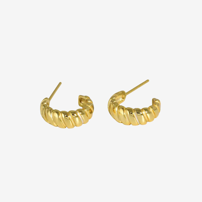 gold huggie hoop earrings worn on model ear close up