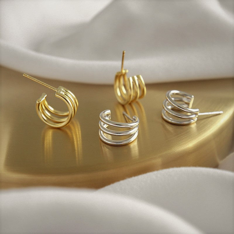 gold triple dot stud earrings worn on model ear