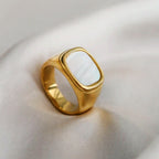 wide gold signet ring worn on model hand