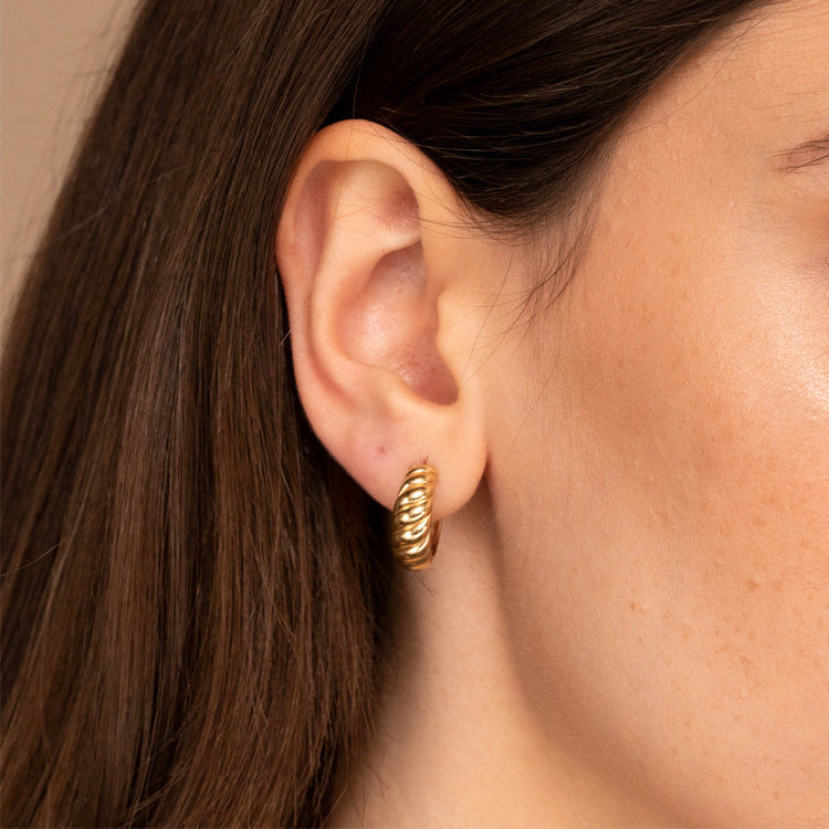 gold croissant hoop earrings worn on model ear