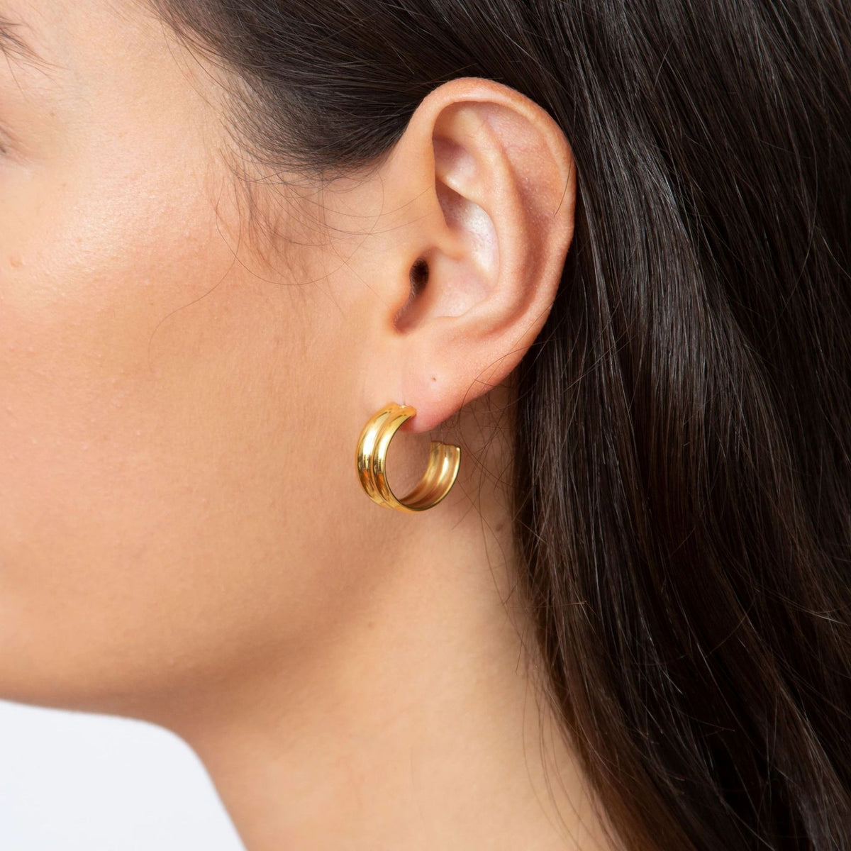 gold double link earrings worn on model ear