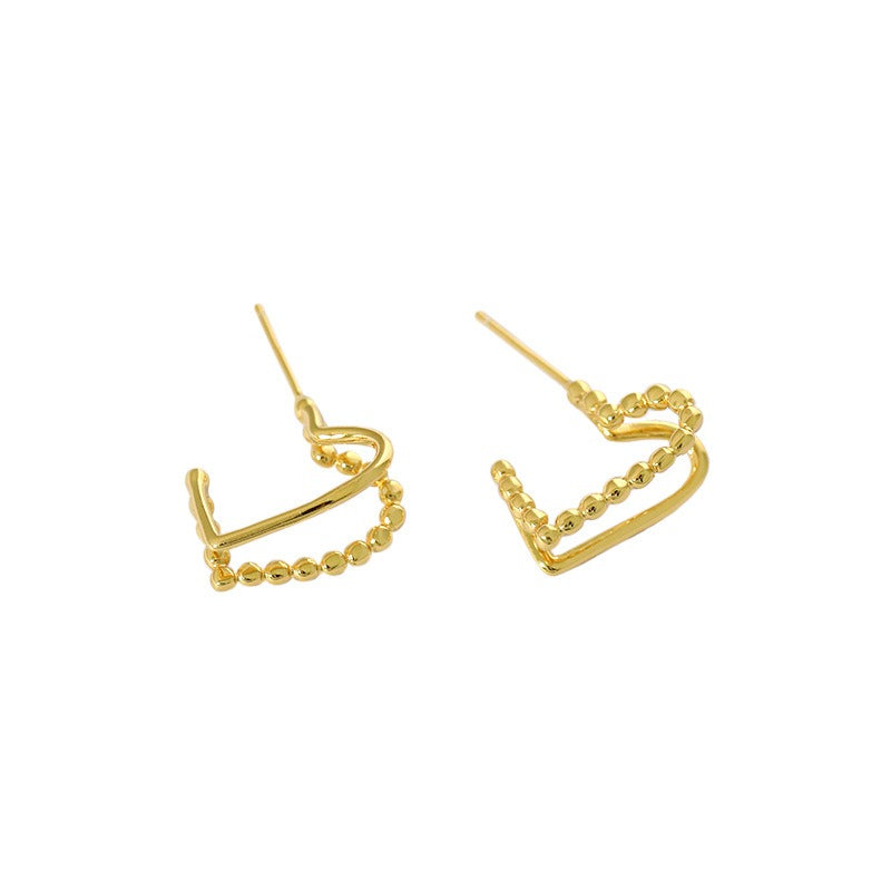 gold love knot stud earrings worn on model ear