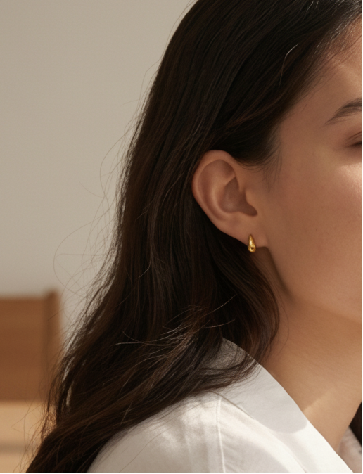 model wearing dainty tear drop gold pvd medical grad stud earrings