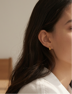model wearing dainty tear drop gold pvd medical grad stud earrings
