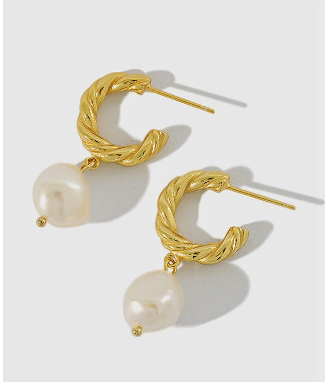 pearl huggie hoop earrings worn on model ear