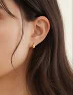 gold teardrop stud earrings worn on model ear close up