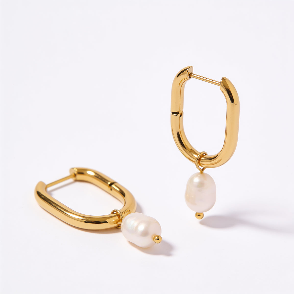gold oval hoop earrings with pearl close up detail